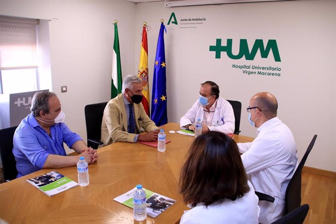 El doctor Miguel Ángel Colmenero y el presidente de ELA Andalucía firman un convenio.