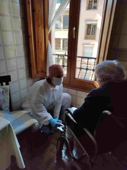 Archivo - Una profesional presta ayuda a domicilio