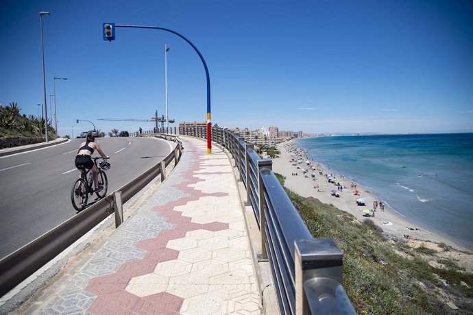 Archivo - Una ciclista circula cerca de la Playa Galúa, en la Manga del Mar Menor, en Cartagena, Región de Murcia (España). 