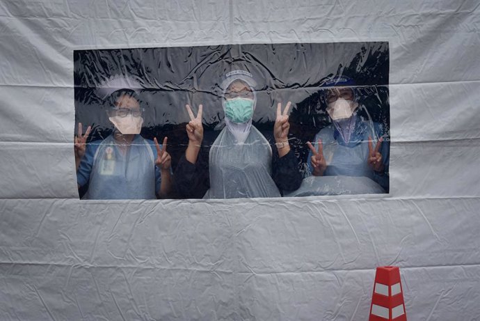 06 July 2021, Malaysia, Labuan: Health workers pose for a picture as they stand inside the vaccine preparation tent to work on the National COVID-19 Immunization Program (PICK) at the Universiti Malaysia Sabah Labuan International Campus (UMSKAL). Photo