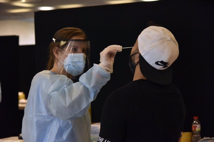 Arxiu - Una treballadora sanitria fa un test d'antígens a un jove