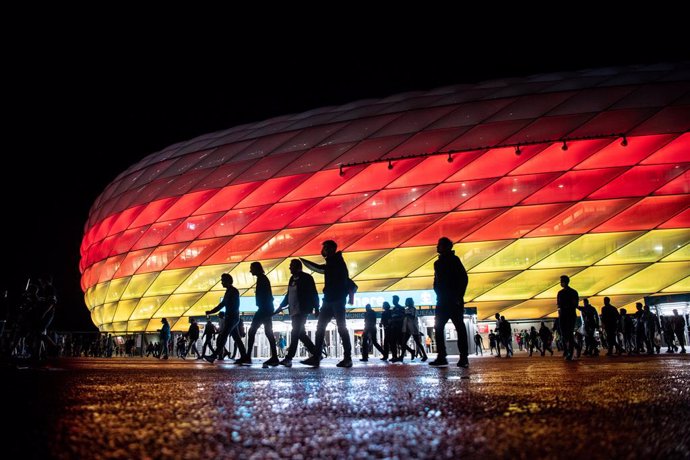 23 June 2021, Bavaria, Munich: Fans leave the Allianz Arena stadium, which is illuminated in the national colours of Germany, after the UEFA EURO 2020 Group F soccer match between Germany and Hungary. Photo: Matthias Balk/dpa