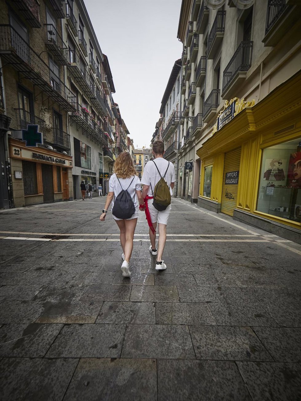 Dos jóvenes pasean por las calles de Pamplona durante el arranque de los No Sanfermines, a 6 de julio de 2021, en Pamplona, Navarra, (España). A pesar de que la ciudad de Pamplona se ha quedado por segundo año consecutivo sin Sanfermines debido a la p
