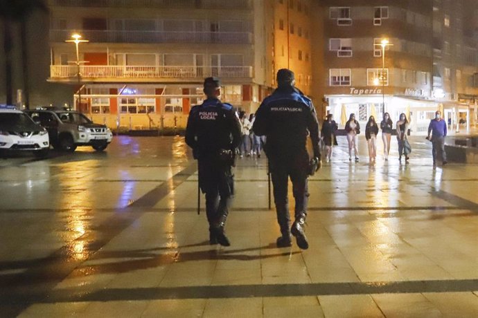 Dos agentes de Policía Local pasean por el Puerto de Sanxenxo para informar en cada uno de los locales de ocio nocturno sobre las nuevas medidas Covid, en Sanxenxo, a 3 de julio de 2021, en Pontevedra, Galicia (España). Las autoridades pueden llegar a m