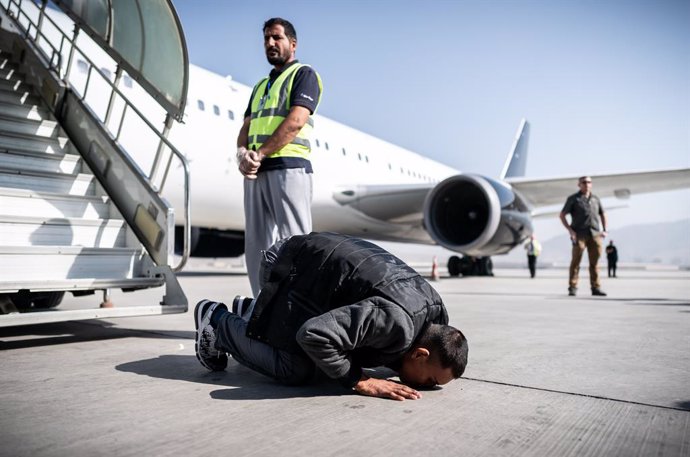 Archivo - 31 July 2019, Afghanistan, Kabul: An Afghan asylum seeker kisses the ground at the airport after leaving a charter plane. 45 rejected asylum seekers were deported form Germany on a special flight to Kabul. Photo: Michael Kappeler/dpa