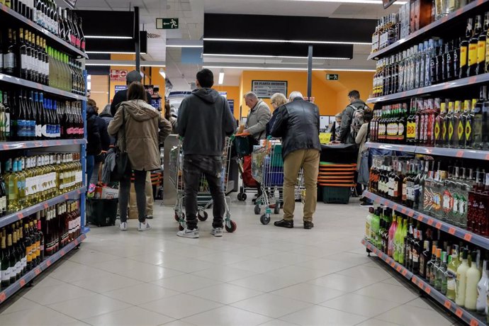 Archivo - Gente haciendo la compra en un supermercado