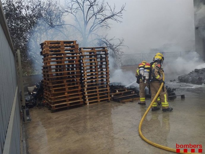 Bomberos trabajando para extinguir el incendio en un polígono de Olesa de Montserrat