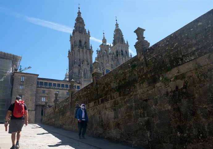 Archivo - Un peregrinos con mascarillas se marcha de la Plaza del Obradoiro, mientras que otro llega, en el primer verano de la pandamia Covid-19, Santiago de Compostela 26 de agosto del 2020