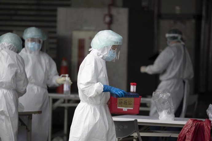 03 July 2021, Taiwan, Taipei: A medical worker wearing protective equipment carries a tray with PCR samples at a testing station in Huannan Nan Market, where Coronavirus infections are significantly rising. Photo: Brennan O'connor/ZUMA Wire/dpa