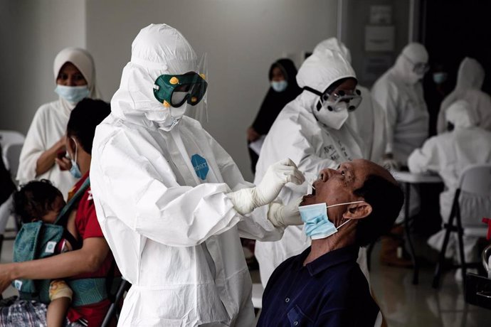 22 June 2021, Indonesia, Central Jakarta: A health worker takes a PCR swab test from a man for the coronavirus test inside the Wisma Atlet Covid-19 Emergency Hospital complex. Photo: Risa Krisadhi/SOPA Images via ZUMA Wire/dpa