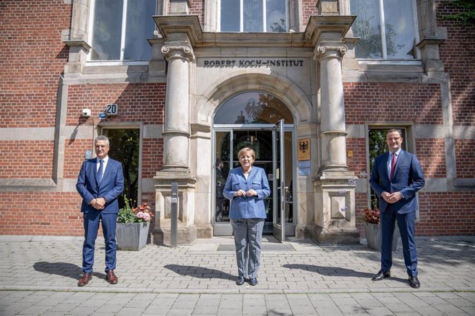 13 July 2021, Berlin: German Chancellor Angela Merkel (C), Germany's Health Minister Jens Spahn (R) and President of the Robert Koch Institute (RKI), Lothar Wieler pose for a picture in front of the entrance to the RKI. Photo: Michael Kappeler/dpa-pool/