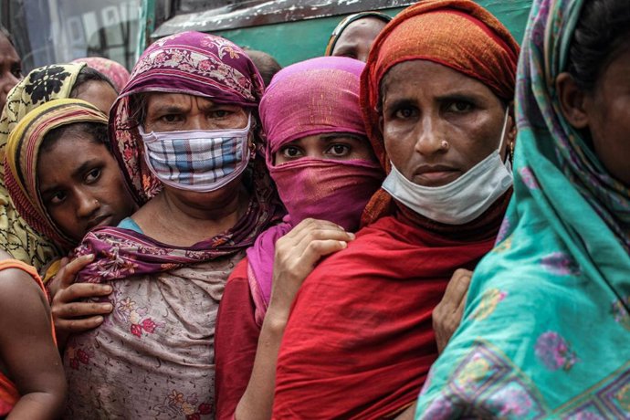 Bangladeshíes esperan en una cola al reparto de comida por parte del Gobierno durante la pandemia de COVID-19. 