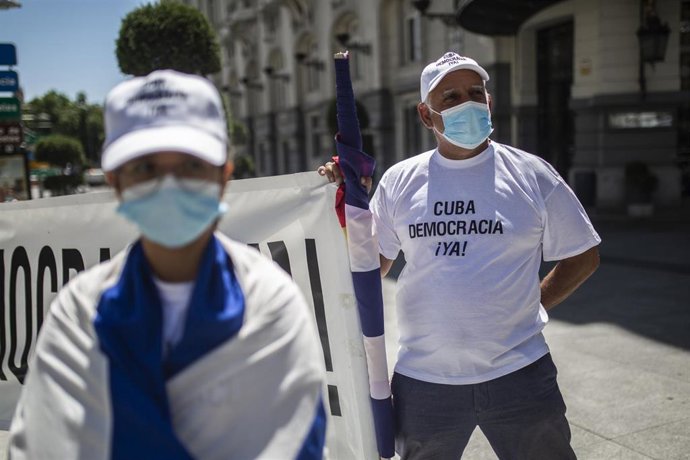 Una persona sostiene una pancarta en el Congreso de los Diputados en apoyo a las movilizaciones contra el Gobierno cubano registradas en la isla