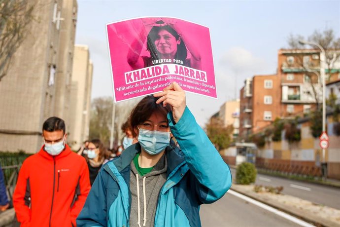 Archivo - Una mujer con un cartel en el que se lee: `Libertad para Khalida Jarrar durante una marcha y batukada feminista en el barrio de Lucero, en Madrid (España), a 5 de marzo de 2021. Esta marcha feminista con motivo del día de la Mujer, el próximo 8