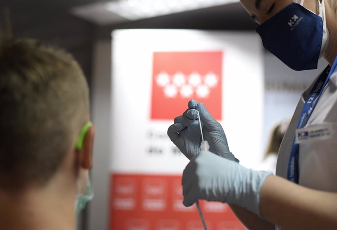 Una sanitaria se prepara para realizar un test de antígenos a un hombre, en un dispositivo de realización de test de antígenos en el intercambiador de Plaza de Castilla, en Madrid (España). 