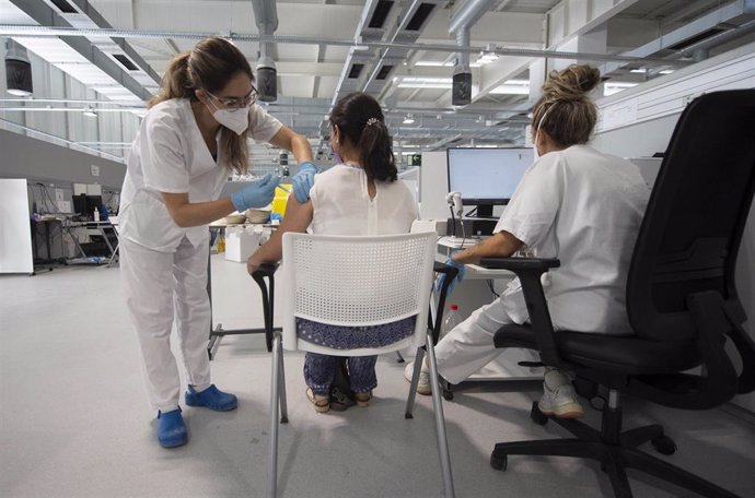 Una joven recibe la primera dosis de la vacuna Pfizer en el Hospital Zendal