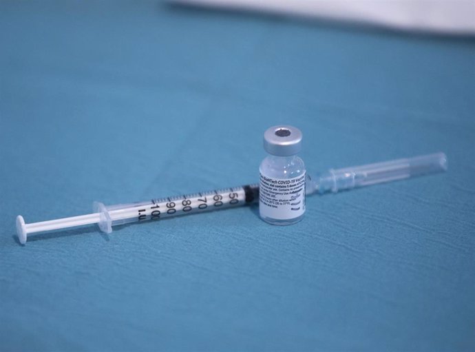 Archivo - Una jeringa junto a un vial de la vacuna de Pfizer / BioNtech contra la Covid-19, foto de recurso