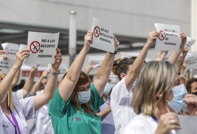 Archivo - Varias personas de Juntas de Personal de departamentos de Salud con carteles, durante una concentración contra el cese de los contratos refuerzo Covid, en la puerta del Hospital de La Fe, a 27 de mayo de 2021, en Valencia, Comunidad Valenciana