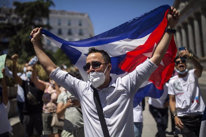 Un hombre sujeta la bandera de Cuba durante una concentración en las inmediaciones del Congreso de los Diputados en apoyo a las movilizaciones contra el Gobierno cubano registradas ayer en la isla, a 12 de julio de 2021, en Madrid (España).