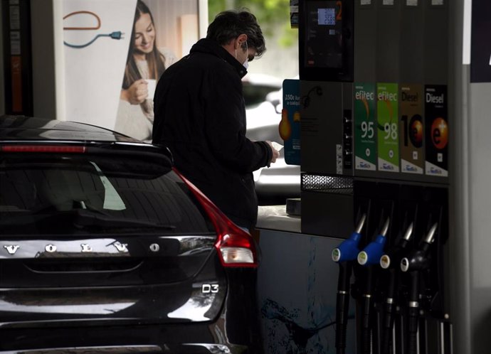 Archivo - Un hombre echa gasolina a su coche.