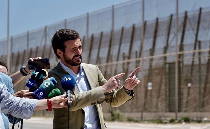 El líder del PP, Pablo Casado, atiende a los medios junto a la valla de Melilla situada entre la frontera de Beni Ensar y la de Barrio Chino. En Melilla, a 14 de julio de 2021.