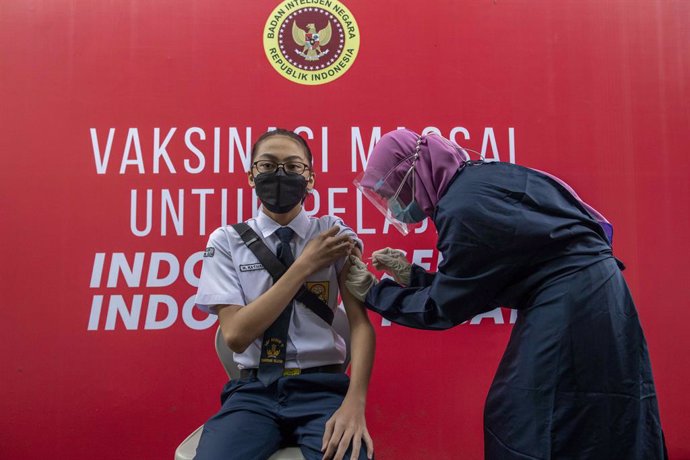 14 July 2021, Indonesia, Tangerang: A healthcare worker injects a child with a dose of a coronavirs vaccine during a mass vaccination campaign for school children aged 12 to 17 years at State Junior High School 11 South Tangerang. Photo: Donal Husni/ZUM