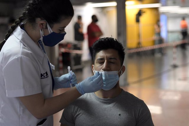 Una sanitaria realiza un test de antígenos a un hombre, en un dispositivo de realización de test de antígenos en el intercambiador de Plaza de Castilla, a 2 de julio de 2021, en Madrid (España).