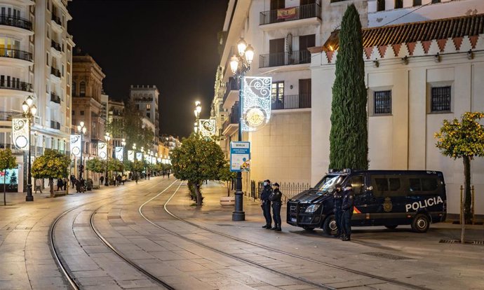 Archivo - Una calle de Sevilla vacía y con presencia policial durante la Nochevieja de 2020.