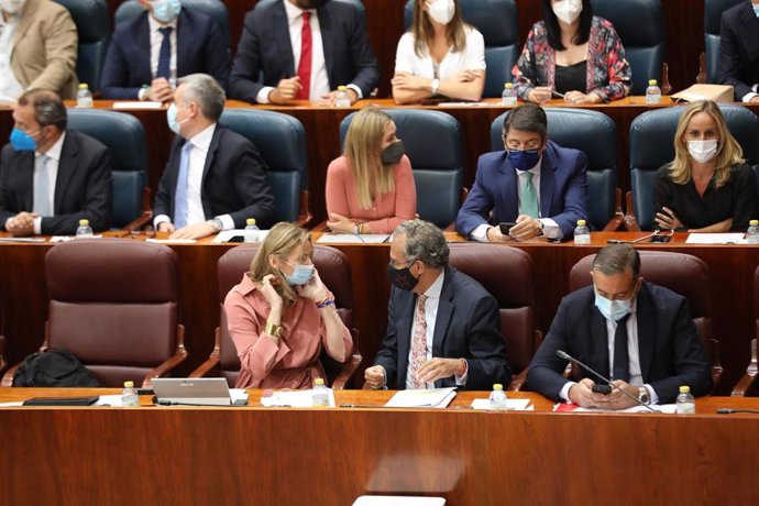 La consejera de Medio Ambiente, Vivienda y Agricultura, Paloma Martín (1i), habla con el consejero de Educación, Universidades, y Ciencia, Enrique Ossorio (centro), durante una sesión de control al Gobierno de la Comunidad de Madrid en la Asamblea de Ma