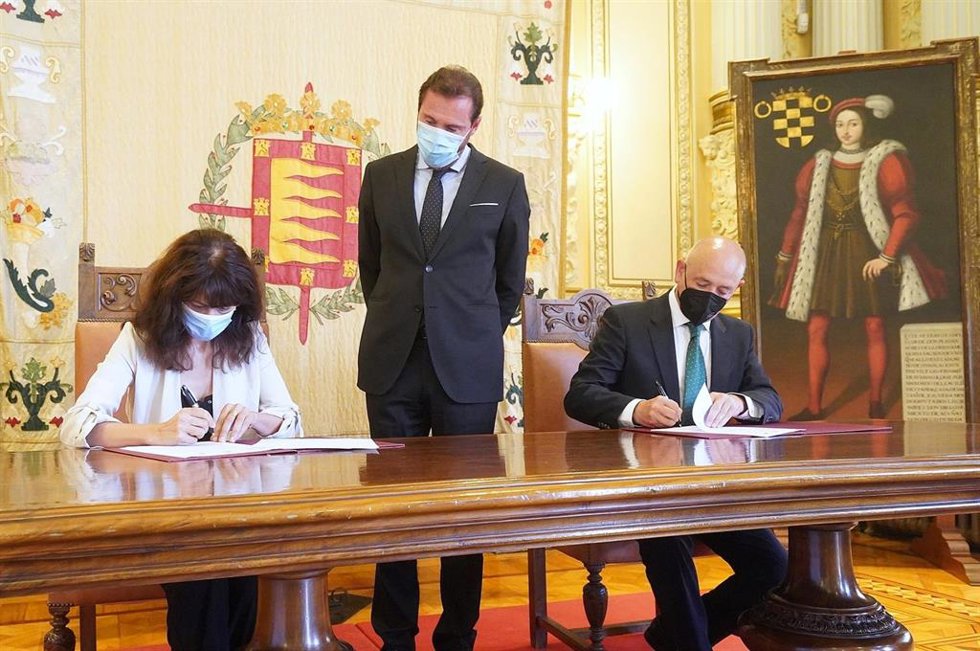 El director de Relaciones Institucionales y Grupos de Interés, Fernando Ríos; y la concejal de Cultura del Ayuntamiento, Ana Redondo, firman el acuerdo de colaboración en presencia del alcalde de la ciudad, Óscar Puente.