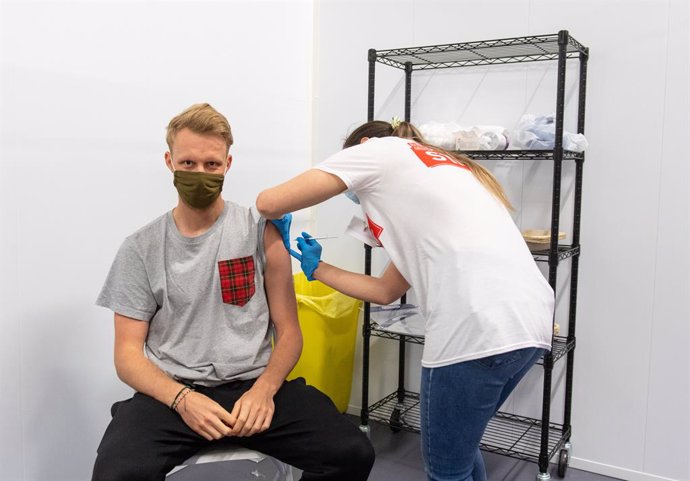 25 June 2021, United Kingdom, London: A man is injected with a dose of Coronavirus vaccine at a Covid-19 vaccination centre in the Emirates Stadium, the football stadium of the English premier league club Arsenal FC. Photo: Dominic Lipinski/PA Wire/dpa