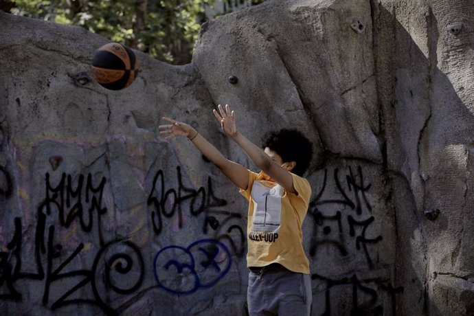 Archivo - Un niño juega al baloncesto.