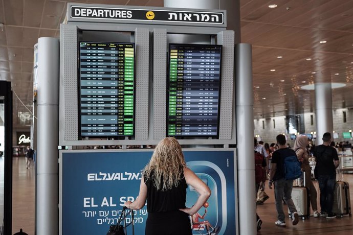 23 June 2021, Israel, Lod: A traveller checks departure information on a display screen at Tel Aviv's Ben Gurion International Airport, where all incoming travellers are tested for COVID-19. Israel has reimposed some coronavirus restrictions after a spi