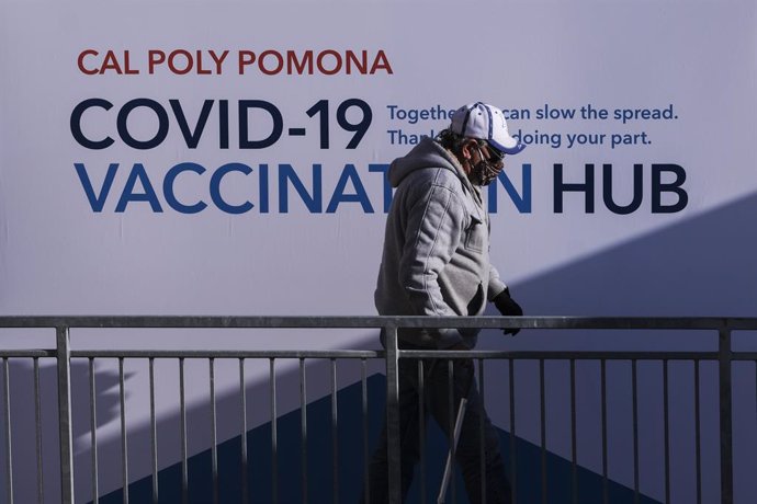 Archivo - 05 February 2021, US, Los Angeles: A senior resident walks by a poster at a mass COVID-19 vaccination site at Cal Poly Pomona. Photo: Ringo Chiu/ZUMA Wire/dpa