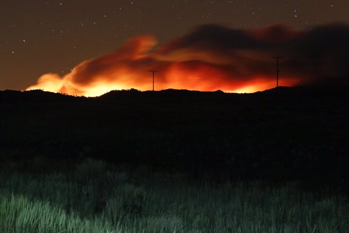 09 July 2021, US, Beckwourth: Flames and smoke rising from the Beckwourth complex wildfire illuminate the sky as it approaches highway 395 in the night. Photo: Ty Oneil/SOPA Images via ZUMA Wire/dpa