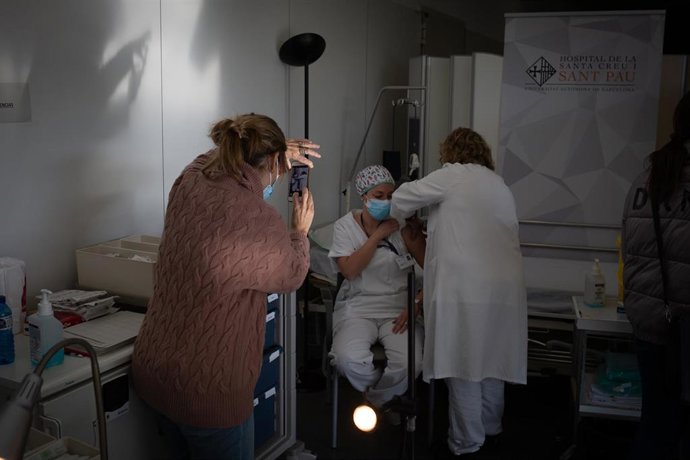 Archivo - Una enfermera vacuna a un profesional sanitario con la vacuna de Pfizer-BioNtech contra el COVID-19 en el Hospital de la Santa Creu i Sant Pau de Barcelona.