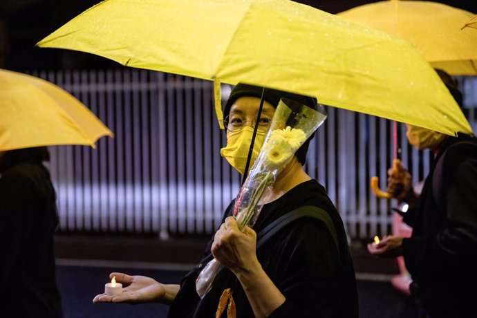 01 July 2021, Japan, Tokyo: A protester holding flowers and an umbrella, during a demonstration to mark the 100th anniversary of the founding of the CCP (Chinese Communist Party) and the 24th anniversary of Hong Kong's handover to China. Photo: Viola Ka