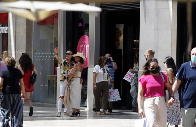 Personas sin mascarilla y otras con mascarilla en la calle Larios, durante el primer día en el que no es obligado el uso de la mascarilla en exteriores desde el inicio de la pandemia, a 26 de junio de 2021, en Málaga (Andalucía), España. El 30 de marzo 