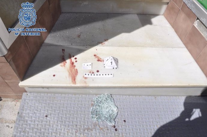 Restos de sangre junto a un cristal del comercio donde un hombre fue sorprendido tras salir de robar en él