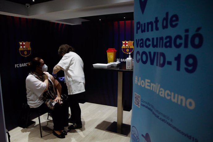 Archivo - Arxivo - Una dona rep la primera dosi de la vacuna de Pfizer contra el Covid-19 en el Camp Nou de Barcelona.