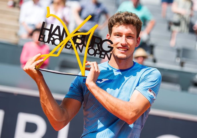 18 July 2021, Hamburg: Spanish tennis player Pablo Carreno Busta celebrates with the trophy after defeating Serbia's Filip Krajinovic in their Men's singles final tennis match of the Hamburg European Open at the Am Rothenbaum stadium. Photo: Daniel Bock