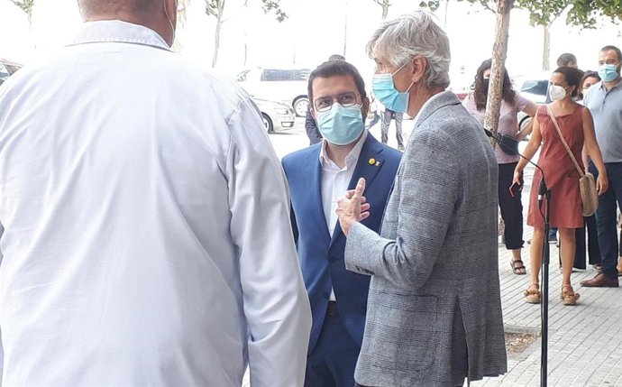 El presidente de la Generalitat, Pere Aragons, conversa con el conseller de Salud, Josep Maria Argimon, y sanitarios del Hospital de Bellvitge tras la rueda de prensa.