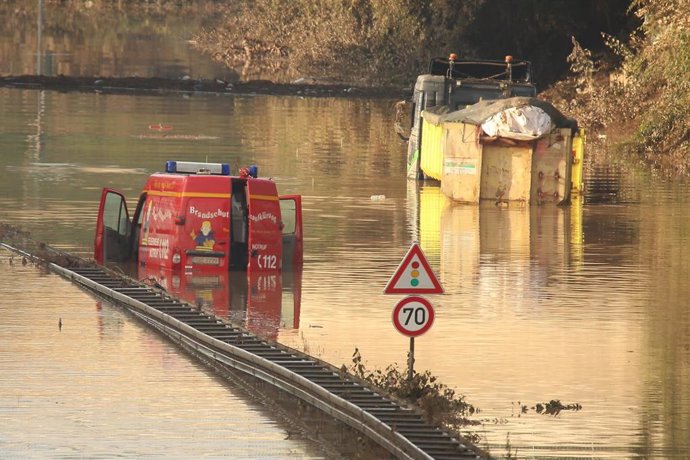 18 July 2021, North Rhine-Westphalia, Erftstadt: A fire brigade emergency vehicle and a truck are still stuck in water on the B265 near Erftstadt Liblar after deadly floods that hit North Rhine-Westphalia. Photo: David Young/dpa