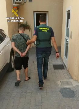 Agentes de la Guardia Civil trasladan a uno de los detenidos