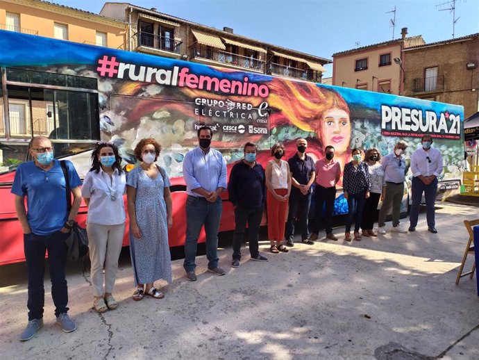 La consejera Esnaola, autoridades locales, participantes en la mesa redonda y responsables de la iniciativa posan junto al autobús en Los Arcos
