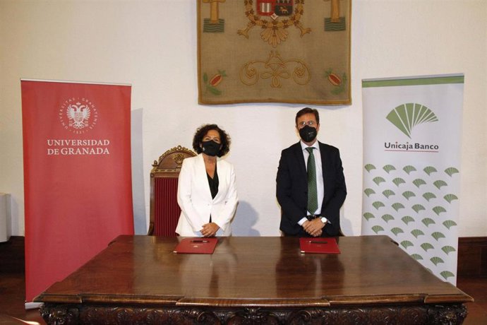 Acto de firma del convenio por el director de área de Granada de Unicaja Banco, Manuel Conde, y la rectora de la Universidad de Granada, Pilar Aranda.
