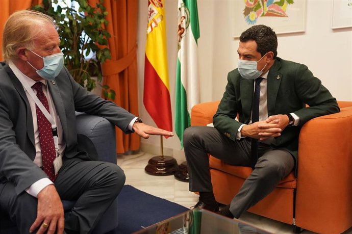 El presidente de la Junta de Andalucía, Juanma Moreno (d), se reúne con representantes de la Confederación Nacional de Asociaciones de Comerciantes de Cascos Históricos de España.