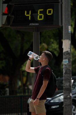 Un hombre bebe agua junto a un termómetro que marca 46 durante un día de alerta roja por altas temperaturas, a 12 de julio de 2021, en la ciudad de Murcia, Murcia (España)