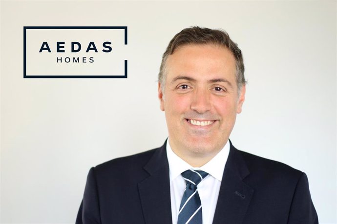 Archivo - El Consejero Delegado de AEDAS Homes, David Martínez, posa delante del logo de la empresa