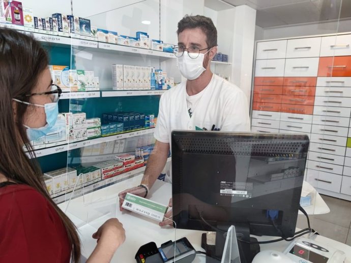 Un farmacéutico dispensa un test de autodiagnóstico
